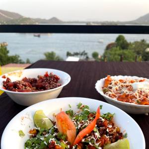 una mesa con tres tazones de comida. en Hotel Lake Star, en Udaipur