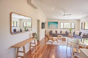 uma sala de estar com um sofá e uma mesa em Away Guesthouse- Away on Shirley Lane em Byron Bay