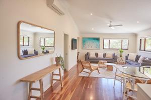una sala de estar con un sofá y una mesa en Away Guesthouse- Away on Shirley Lane, en Byron Bay