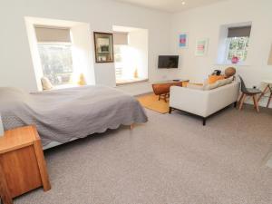 a bedroom with a bed and a couch and a chair at Cheviot View in Cornhill-on-tweed
