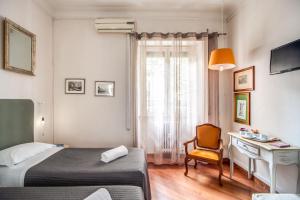 a bedroom with a bed and a desk and a chair at Circus Maximus B&B in Rome