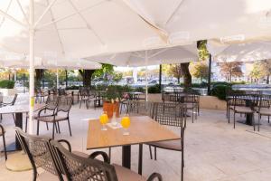 un restaurante vacío con mesas, sillas y sombrillas en Hotel Continental, en Rijeka