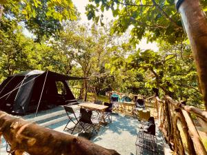 namiot oraz stół i krzesła na patio w obiekcie Windfarm Nature Escape w mieście Pililla