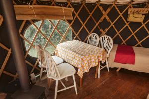 a room with a table and chairs and a bed at Beech Yurt in Fernhurst