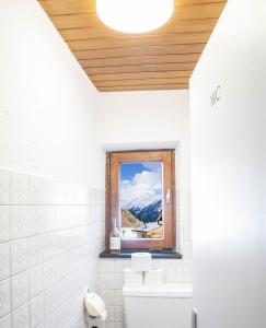 baño con ventana con vistas a la montaña en Pension Grünwald, en Sölden