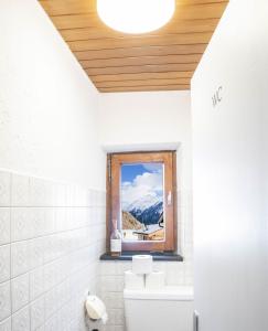 a bathroom with a window with a view of a mountain at Pension Grünwald in Sölden