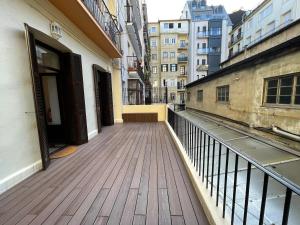 un balcón con suelo de madera y edificios en Churruca apartment with terrace, en San Sebastián