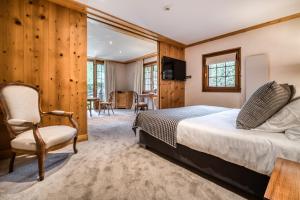 - une chambre avec un lit et une chaise dans l'établissement Auberge du Bois Prin, à Chamonix-Mont-Blanc