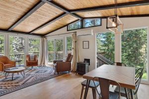 a living room with a table and chairs and windows at Nature Stay with Views Like No Where Else in Custer