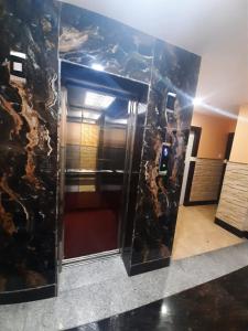 a bathroom with a black marble wall with a elevator at HOTEL SANDSTONE INTERNATIONAL in Kolkata