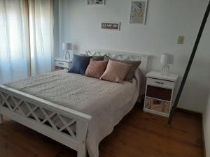 Un dormitorio con una cama blanca con almohadas. en Dúplex El Origen en Concepción del Uruguay