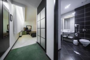 łazienka z toaletą, umywalką i wanną w obiekcie Hotel Astory Plzeň w Pilznie