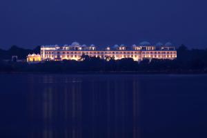a large building lit up at night next to a lake at Radisson Blu Udaipur Palace Resort & Spa in Udaipur
