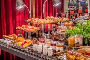 - un buffet composé de différents types de pain et de viennoiseries dans l'établissement Hotel Trianon Rive Gauche, à Paris