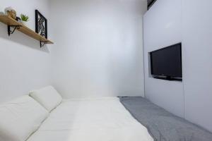 ベエルシェバにあるUnique Central Old Town Studio Apartmentの白い部屋(ベッド1台、テレビ付)
