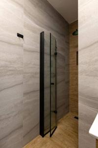 a shower with a glass door in a bathroom at Unique Central Old Town Studio Apartment in Beer Sheva