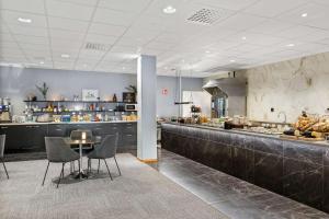 a restaurant with a counter and a table and chairs at Best Western Malmia Hotel in Skellefteå