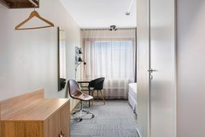Habitación con escritorio, cama y espejo. en Best Western Malmia Hotel, en Skellefteå