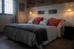 a bedroom with a large bed with red and blue pillows at Casa Rural Eralta in Dúrcal