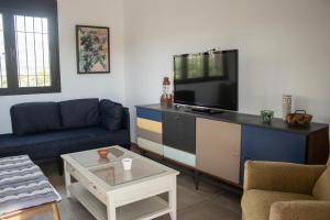 sala de estar con sofá azul y TV en Casa Rural Eralta, en Dúrcal