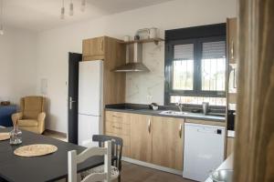 eine Küche mit einem Tisch und einem weißen Kühlschrank in der Unterkunft Casa Rural Eralta in Dúrcal