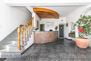 un hall avec un escalier et une plante en pot dans l'établissement Residencial Lareira do Pinheirinho, à Almada