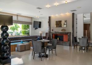 a living room with a fireplace and a table and chairs at Danai Hotel & Spa in Olympiaki Akti