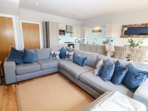 a living room with a gray couch with blue pillows at Sandy House in Rhosneigr