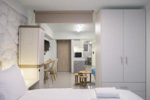 Fully renovated underground flat in Pagrati في أثينا: غرفة نوم بسرير ابيض وطاولة +16 صورة