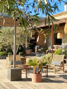 a patio with chairs and trees and a building at Villa Cabrida in Cabrières-dʼAvignon