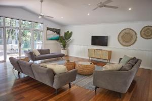 sala de estar con 2 sofás y TV en Sunrise Guesthouse en Byron Bay