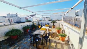 een patio met een tafel en stoelen op een balkon bij Giada House in Porto Cesareo