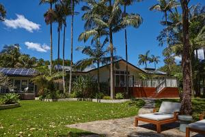 a house with palm trees in front of it at Sunrise Guesthouse in Byron Bay