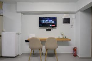 Fully renovated underground flat in Pagrati في أثينا: غرفه بطاوله وكرسيين وتلفزيون