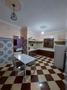eine Küche mit einem Tisch und einem karierten Boden in der Unterkunft RESIDENCE ABOU YASSINE in Ad-Dakhla
