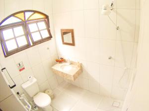 La salle de bains est pourvue d'un lavabo, de toilettes et d'une douche. dans l'établissement 4 Estações - Arraial, à Arraial do Cabo