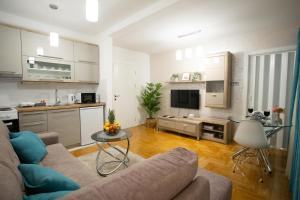un soggiorno con divano e una cucina di Apartman SUNSET a Sremska Mitrovica