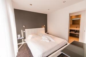 a bedroom with a white bed and a table at Chambres d'Hôtes de l'Avel Vor in Port-Louis