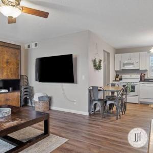 a living room with a table and a television on a wall at Pet Friendly Large Fenced Backyard Covered Patio in Rapid City
