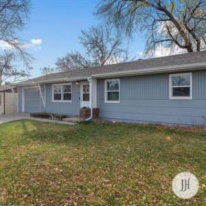 a blue house with a yard with a house at Pet Friendly Large Fenced Backyard Covered Patio in Rapid City