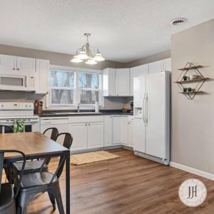 a kitchen with a table and a white refrigerator at Pet Friendly Large Fenced Backyard Covered Patio in Rapid City