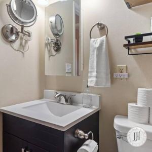 a bathroom with a sink and a mirror and a toilet at Pet Friendly Large Fenced Backyard Covered Patio in Rapid City