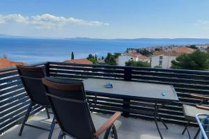 uma mesa e cadeiras numa varanda com vista para o oceano em Apartment Vista Oasis with Pool and Terrace em Trogir