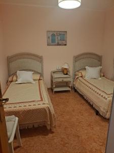 ein Schlafzimmer mit 2 Betten und einem Tisch mit einer Lampe in der Unterkunft Mari Carmen, 2º-8 in Cullera