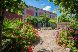 a garden with flowers in front of a building at Tenuta TerraRossa in Rossano +65 photos