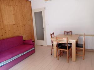 uma sala de estar com uma mesa e um sofá roxo em Apartamento 3 habitaciones centro de Torredembarra em Torredembarra