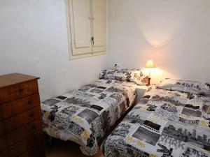 um quarto com 2 camas e uma cómoda em Apartamento 3 habitaciones centro de Torredembarra em Torredembarra