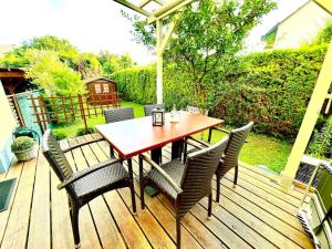 een houten terras met een houten tafel en stoelen bij Schöne Wohnung mit eigenen Eingang und Terrasse in Gösseling