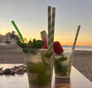 zwei Cocktails auf einem Tisch am Strand in der Unterkunft Piso Los Angeles - 1ra Linea de Playa in Denia