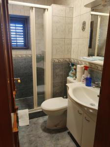 a bathroom with a toilet and a sink and a shower at Soleil Apartmanok Baska in Baška